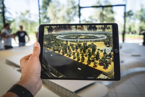 Tablet zobrazujúci vizualizáciu areálu stromov a modernej stavby.