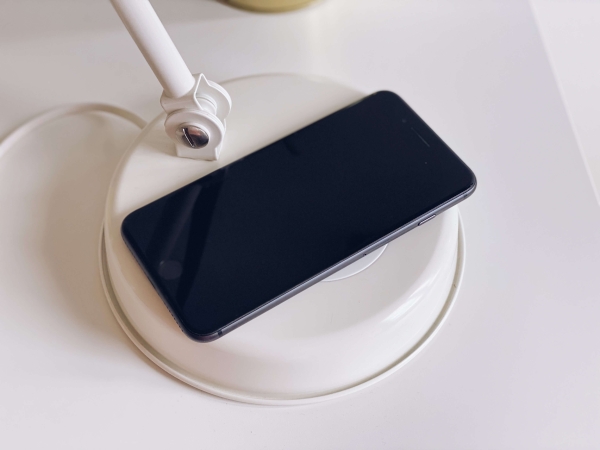  Smartfón nabíjajúci sa na bezdrôtovej nabíjačke v lampe